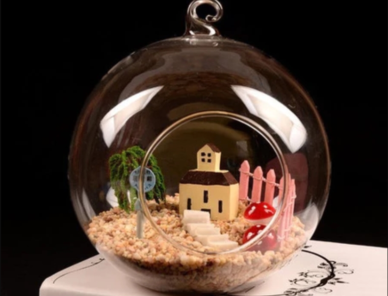 glass-vase terrarium with a miniature house